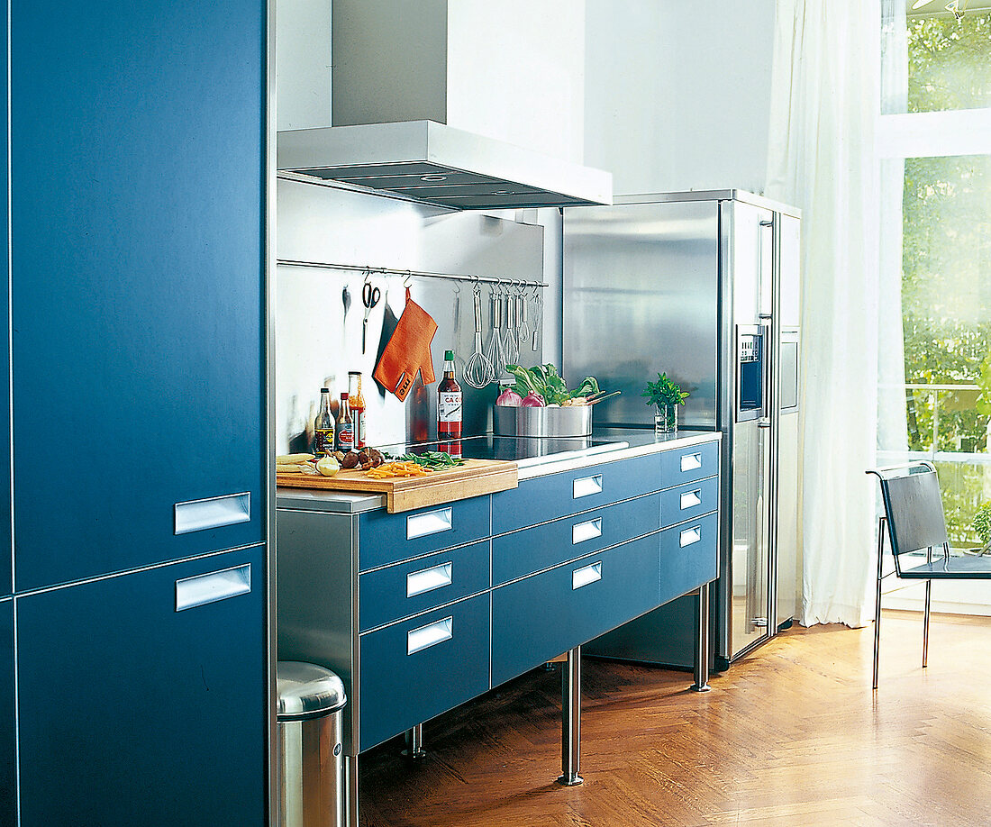 Helle Küche in Blau und Metallic, Arbeitsfläche mit Abzugshaube