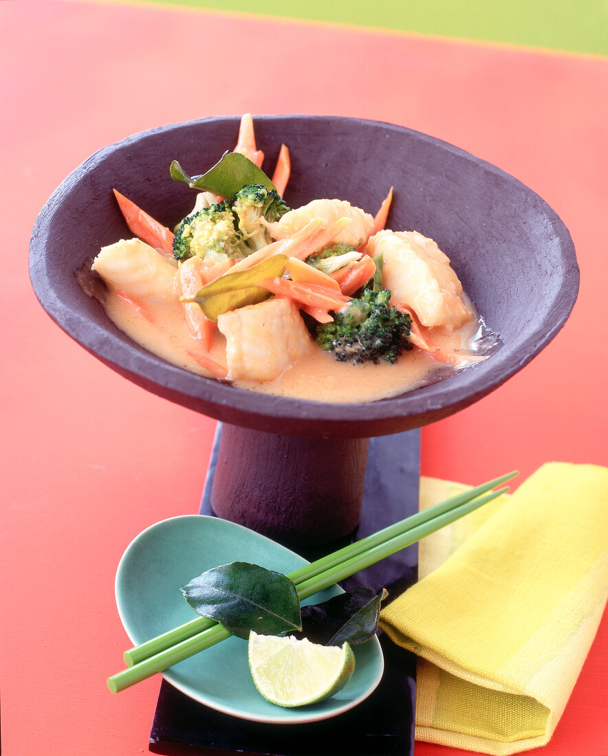 Fish and vegetable curry on purple standing bowl