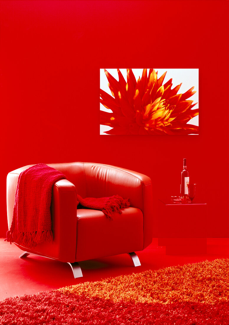Red leather chair with blanket in front of red wall