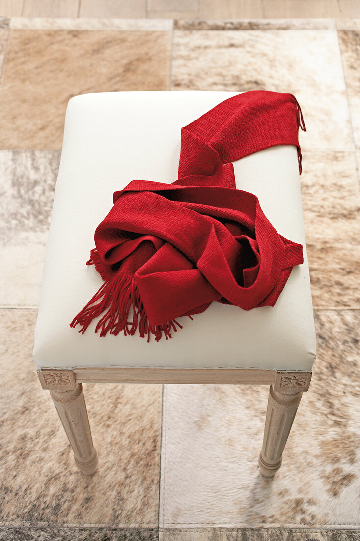 Red scarf on white stool