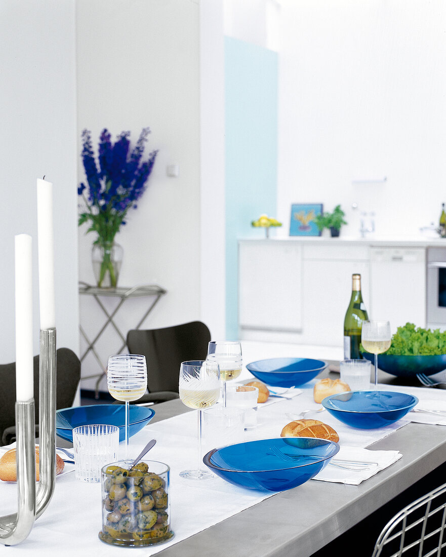 Table laid out with candles, glasses and blue bowls