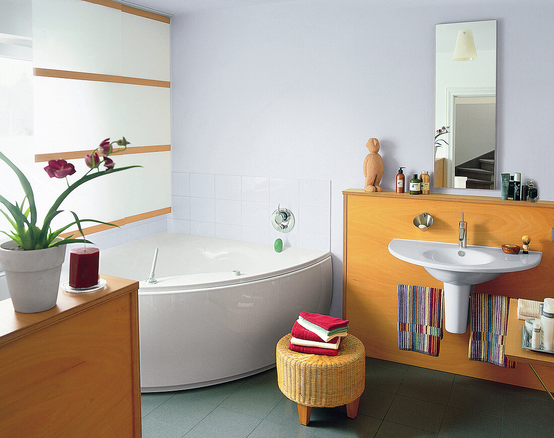 Interior of bathroom with wood and ceramic bathtub and sink