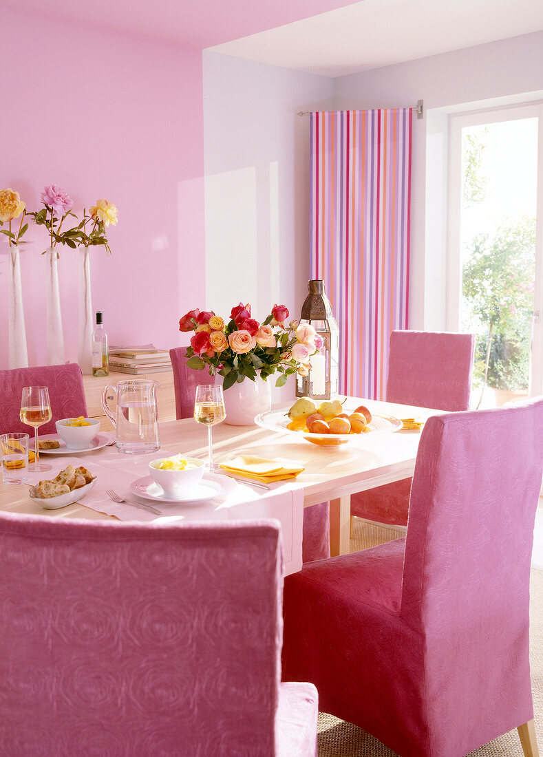 Essplatz in rosa mit Vasen auf Regal vor rosa Wand