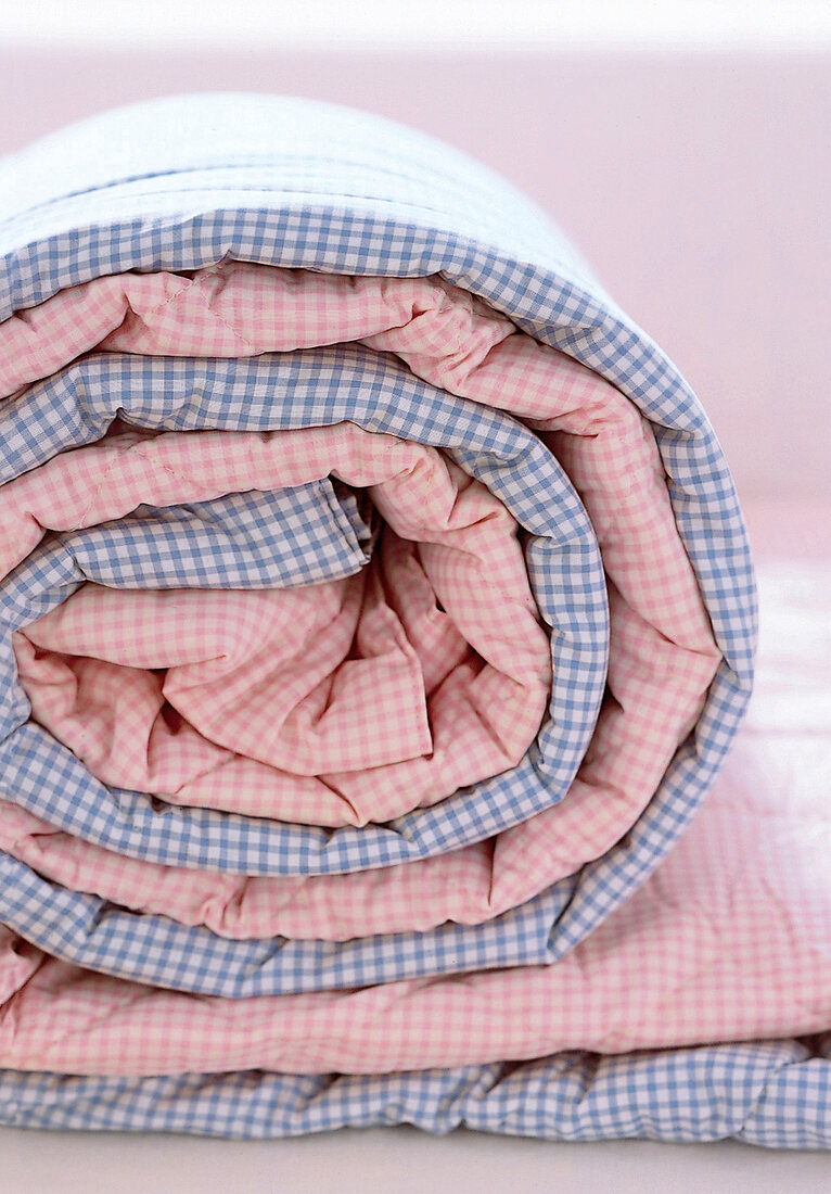 Karierte Decken gerollt, rosa und blau.