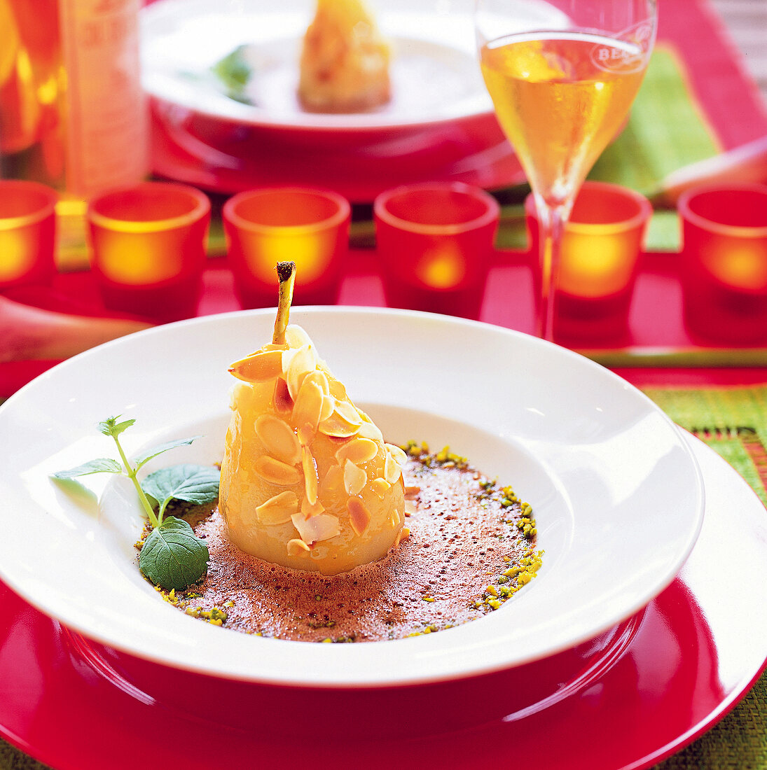 Wine pear with chocolate sabayon and almonds flakes in bowl