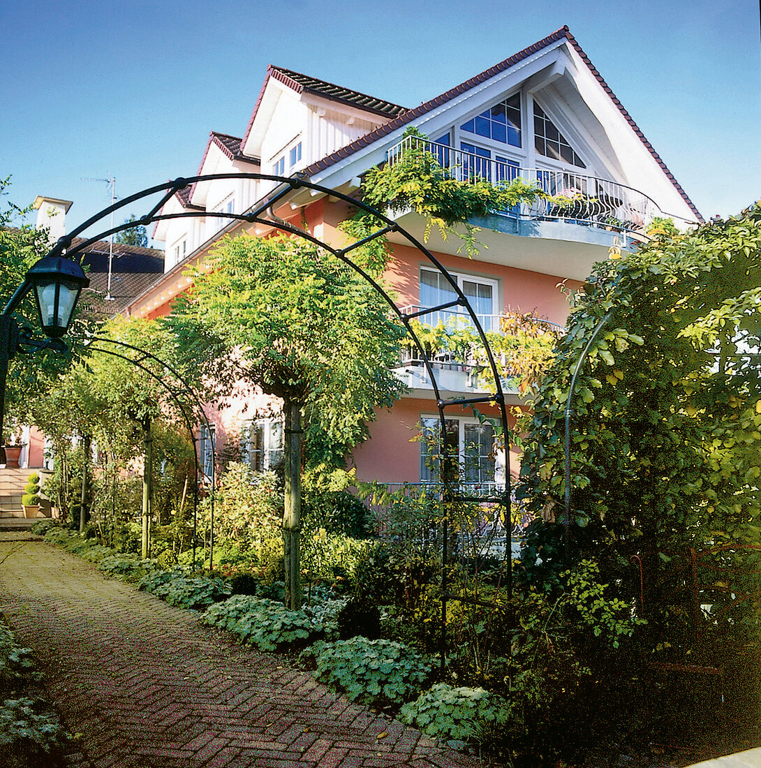Zweistöckiges Haus mit Dachgeschoss im üppigen Garten, viele Balkons