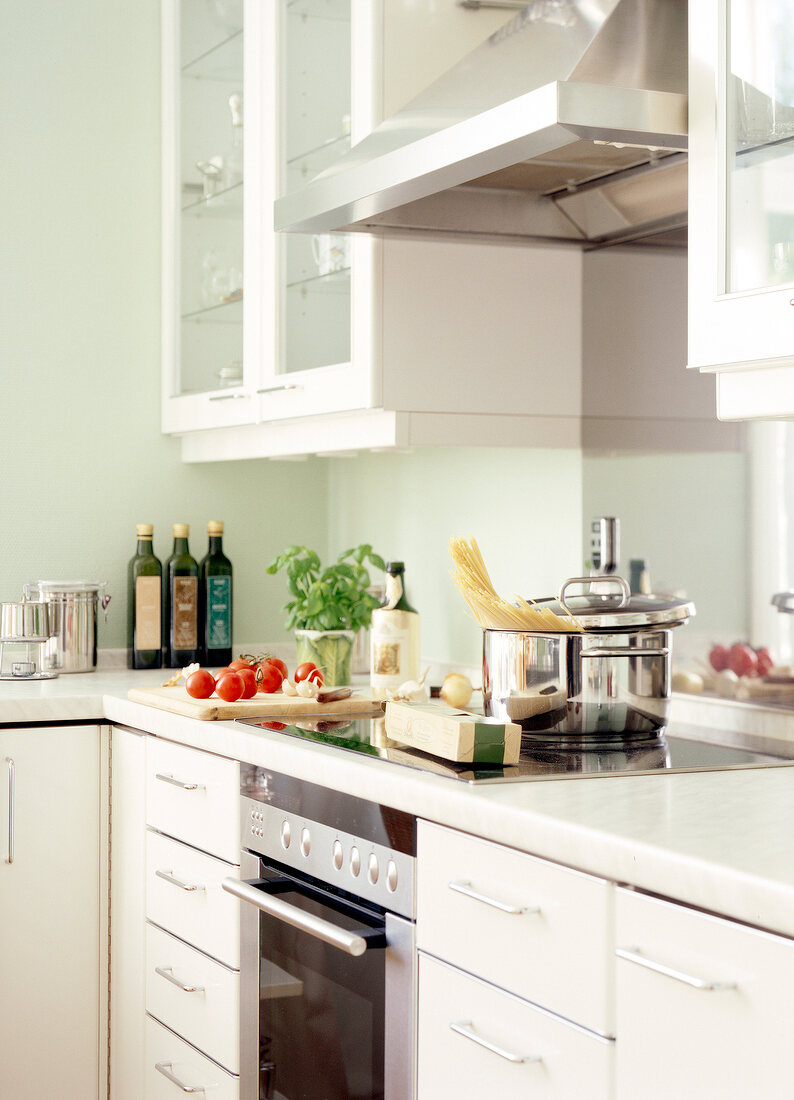 Kitchen with white cabinets and pot with lid on ceramic hob