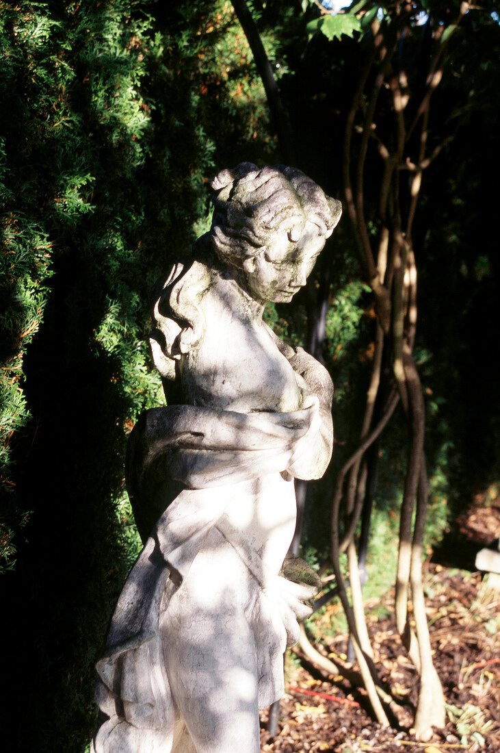 Frauenfigur im üppigen Garten, Sommer
