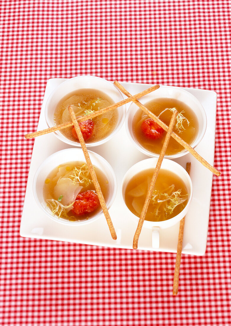 Four bowls with cabbage soup and donuts on serving plate