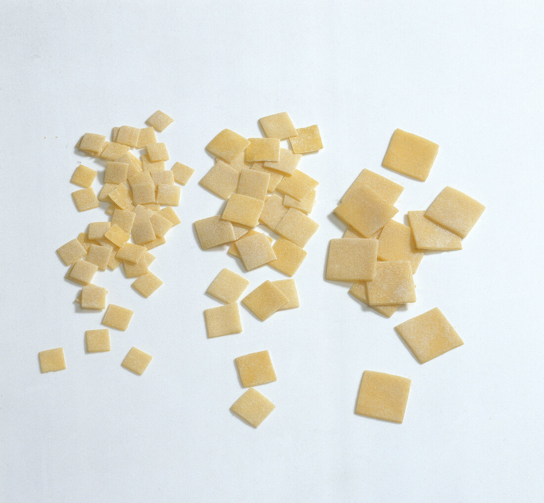 Different sizes of quadrucci pasta dough on white background