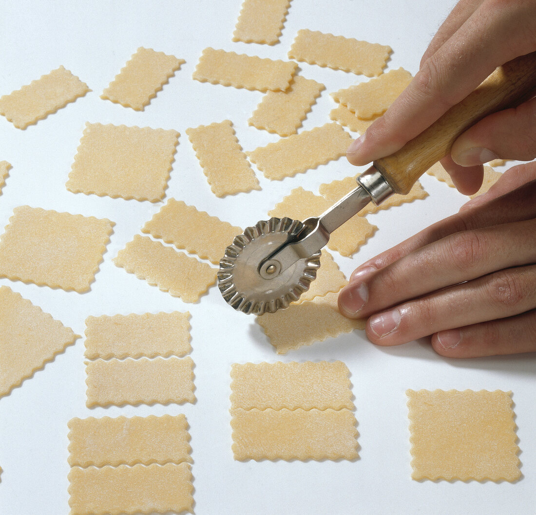 Hand cutting dough into squares and rectangles for preparing farfalle pasta, step 2