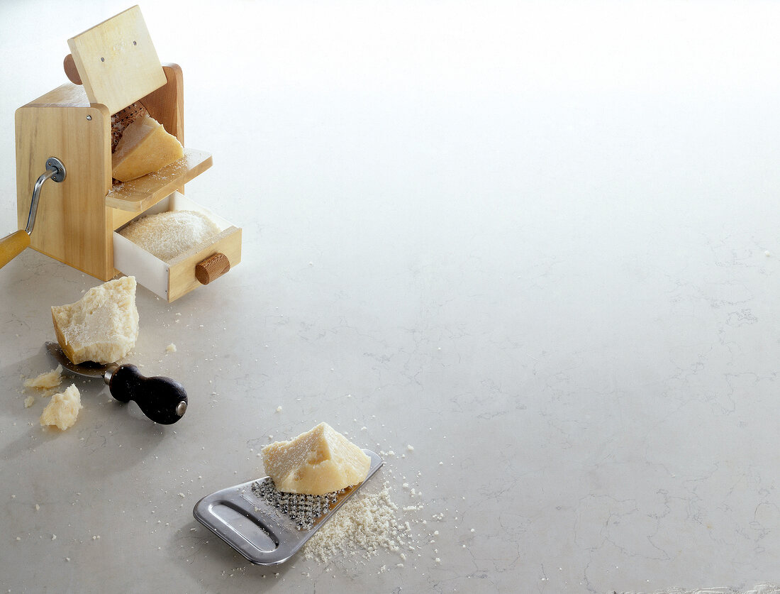 Cheese and cheese graters on white background, copy space