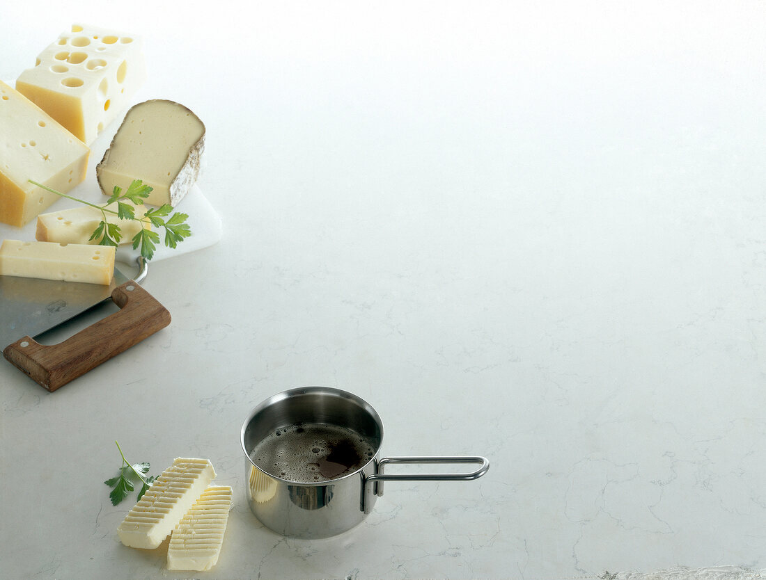 Melt butter, fresh butter, mountain cheese and emmentaler on white background, copy space