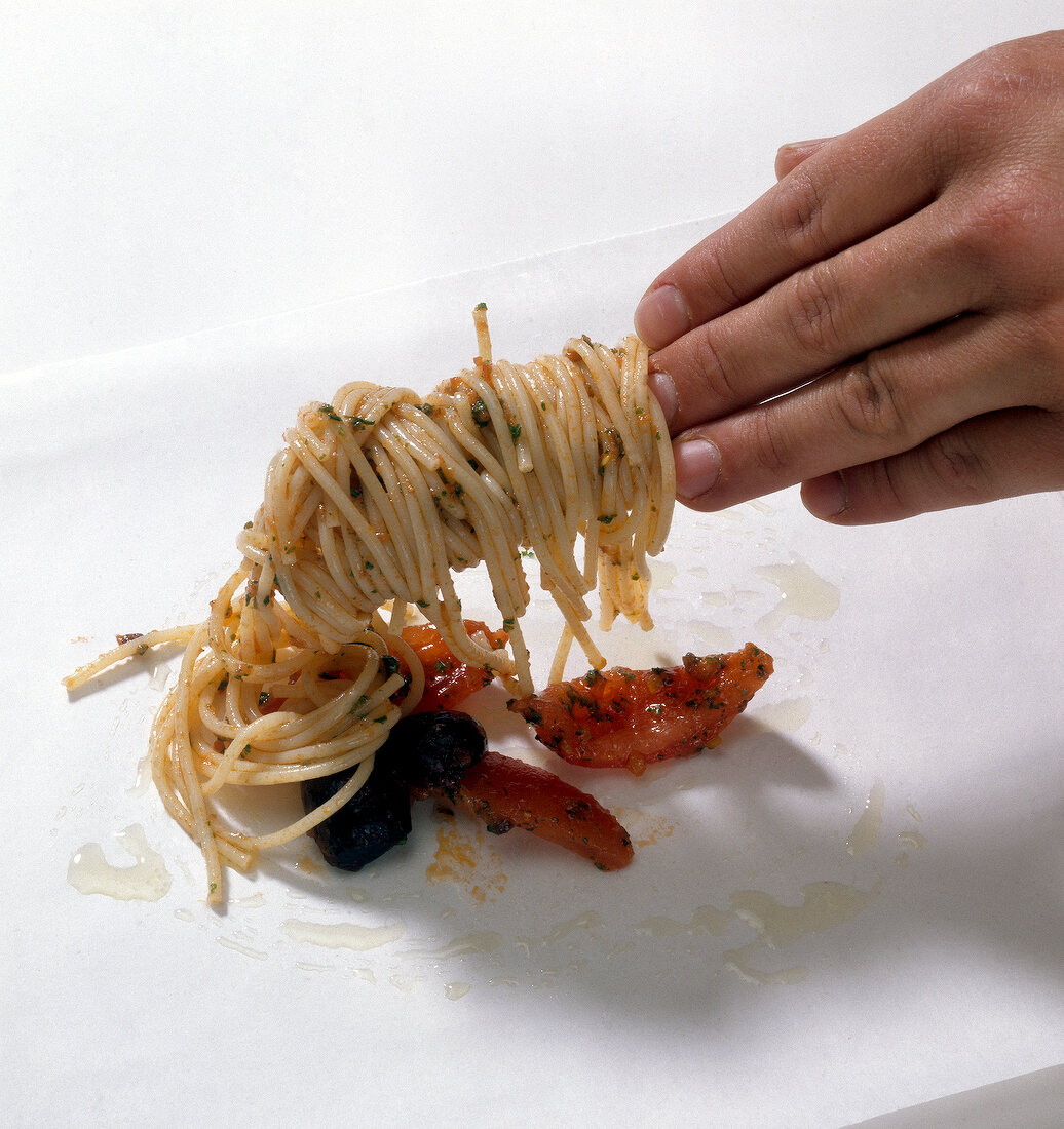 Noodles being placed on parchment paper, step 1