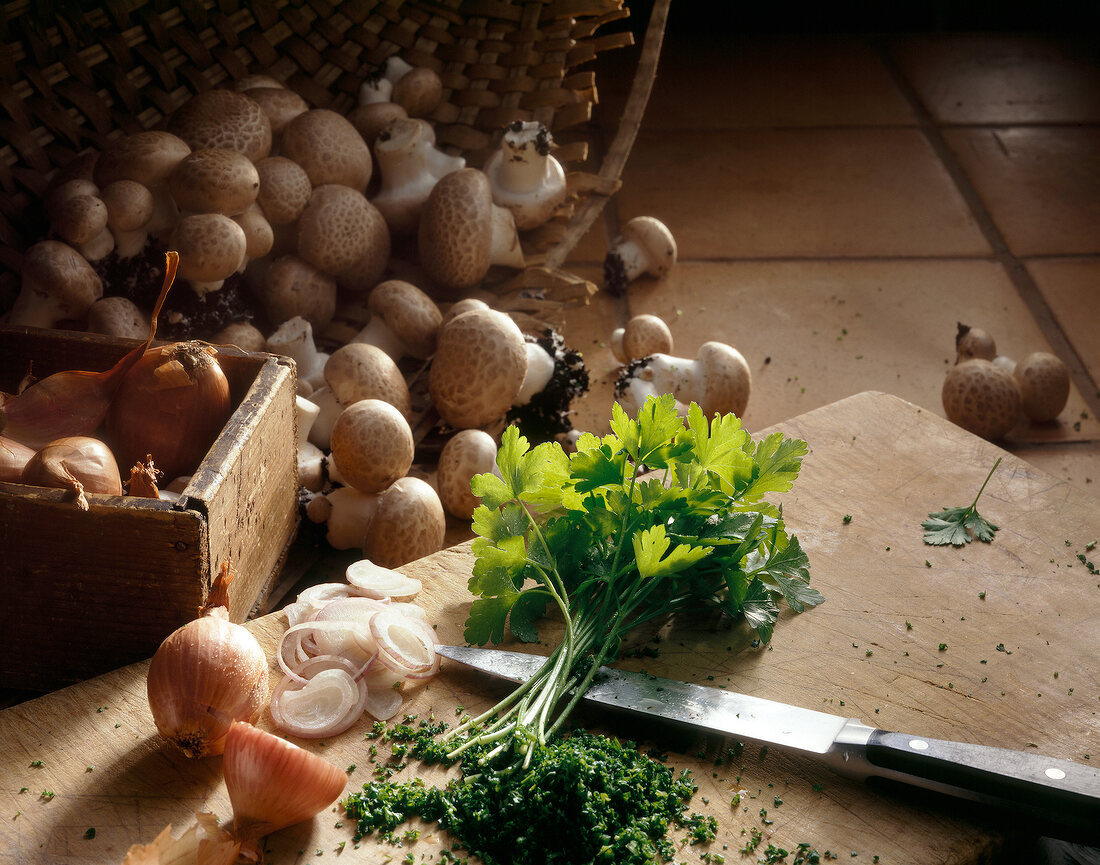 Herbs and onion on cutting board with mushrooms