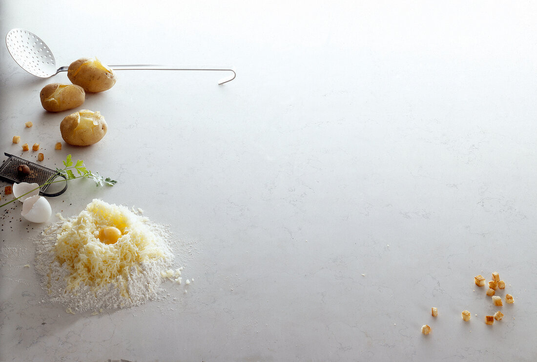 Potatoes, egg yolk, egg shell, nutmeg and breadcrumbs on white background, copy space