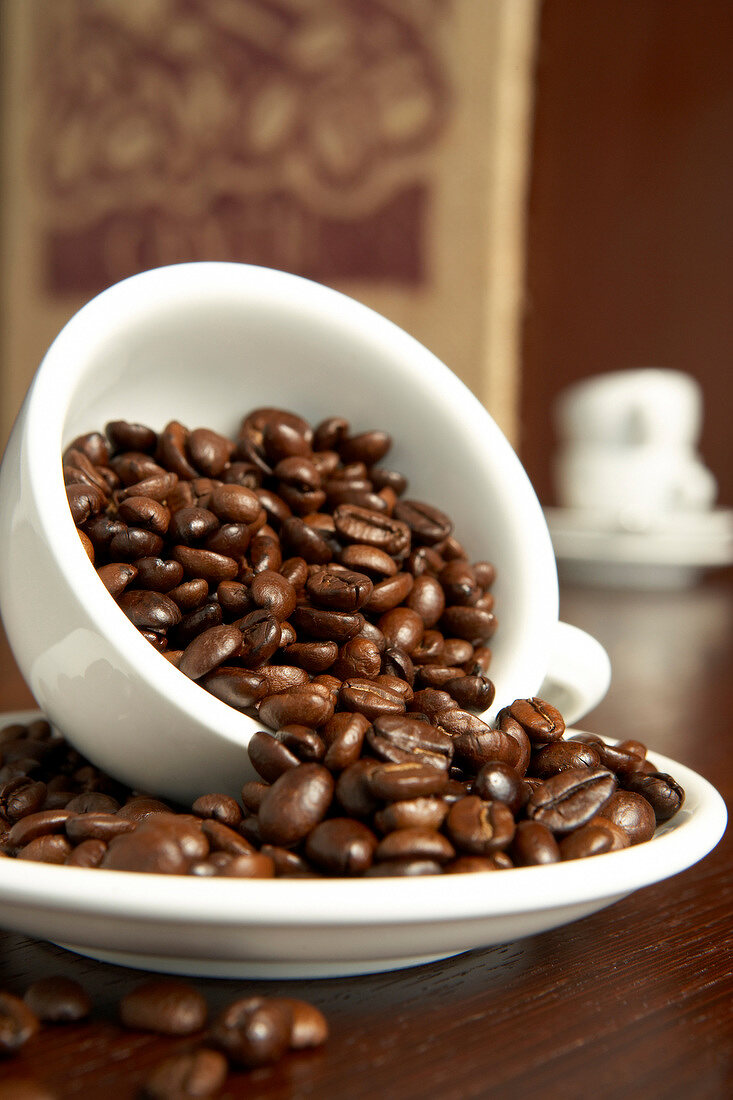 Kaffeebohnen in einer Tasse und Unterrtasse