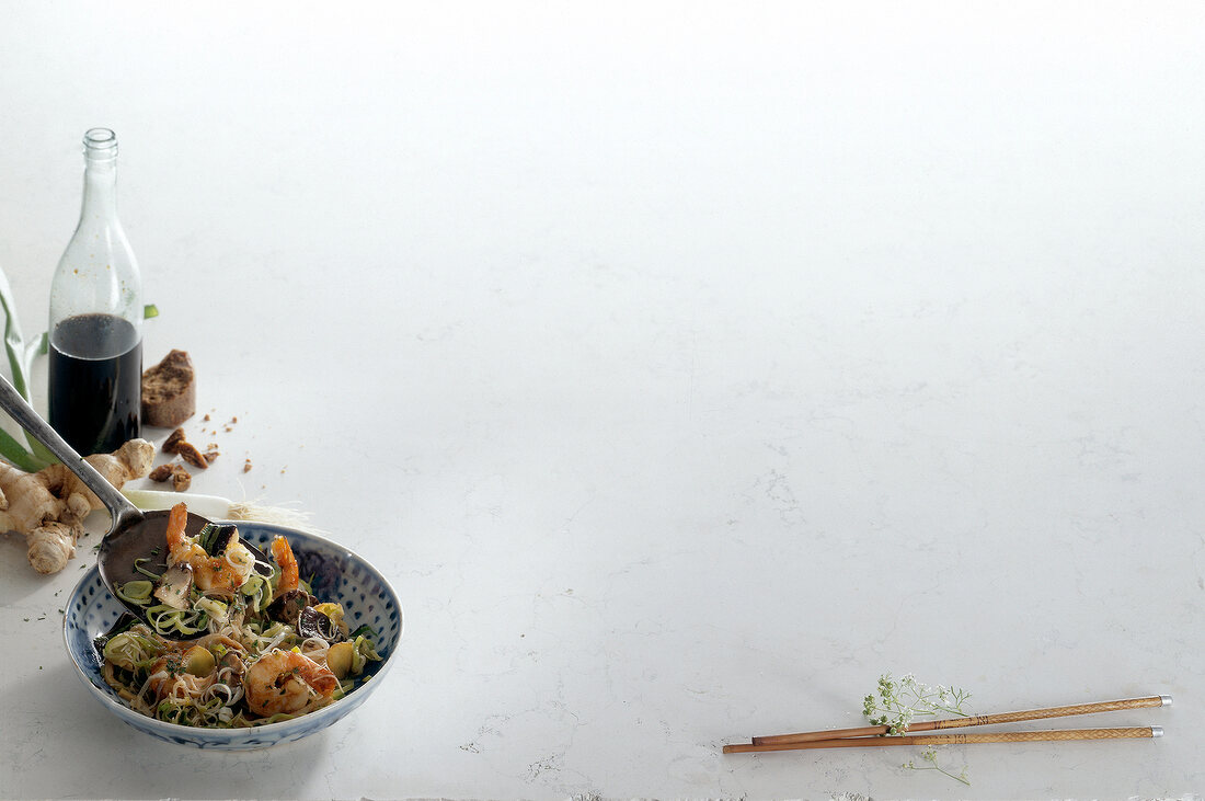 Shrimp with rice noodles in bowl on white background, copy space