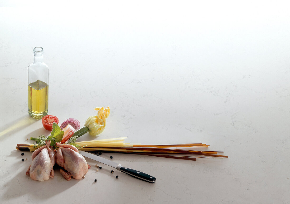 Chicken, leek, tomato, zucchini and olive oil on white background, copy space