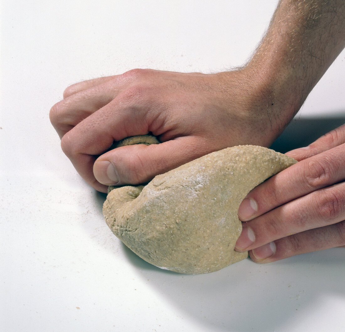 Close-up of man's hands kneading dough