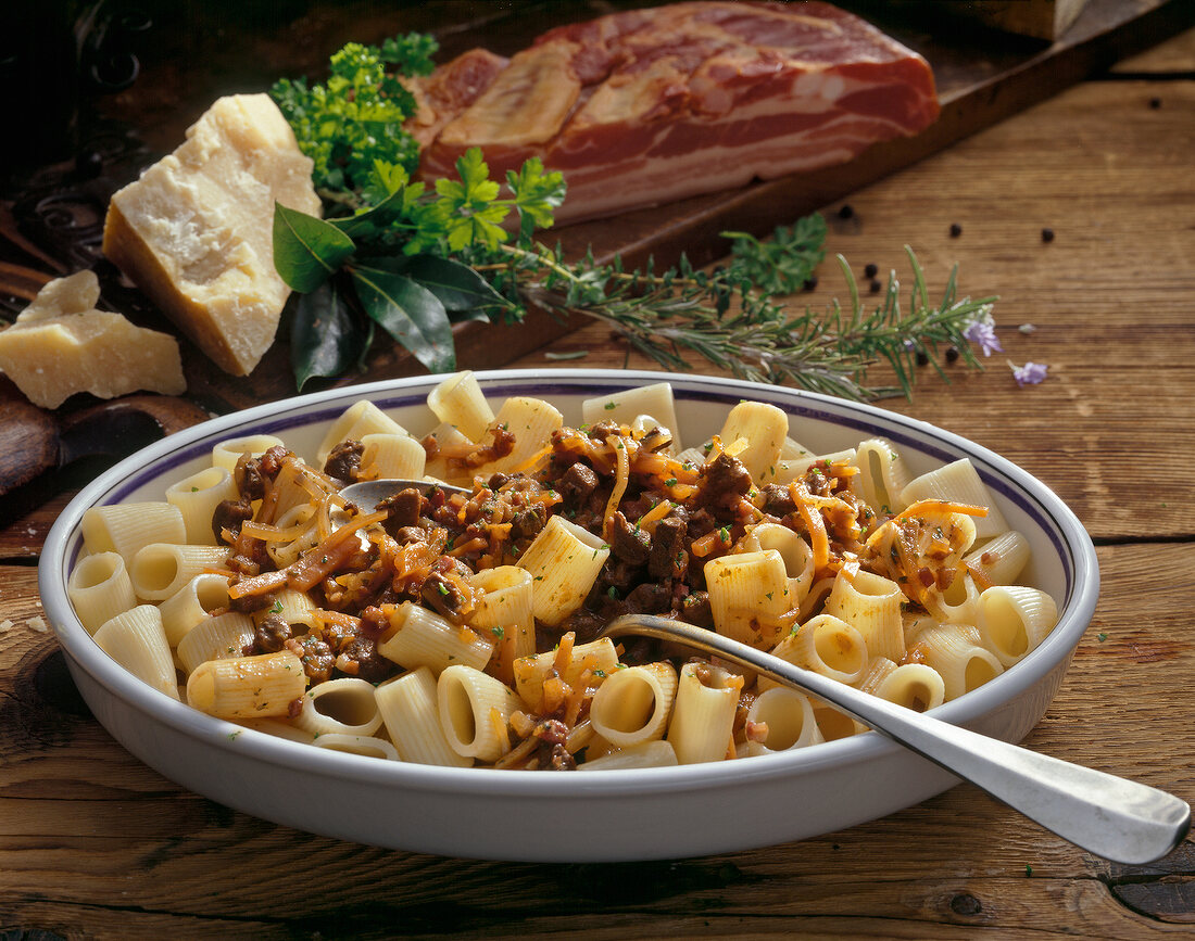 Pasta with wild duck ragout in serving dish with spoon