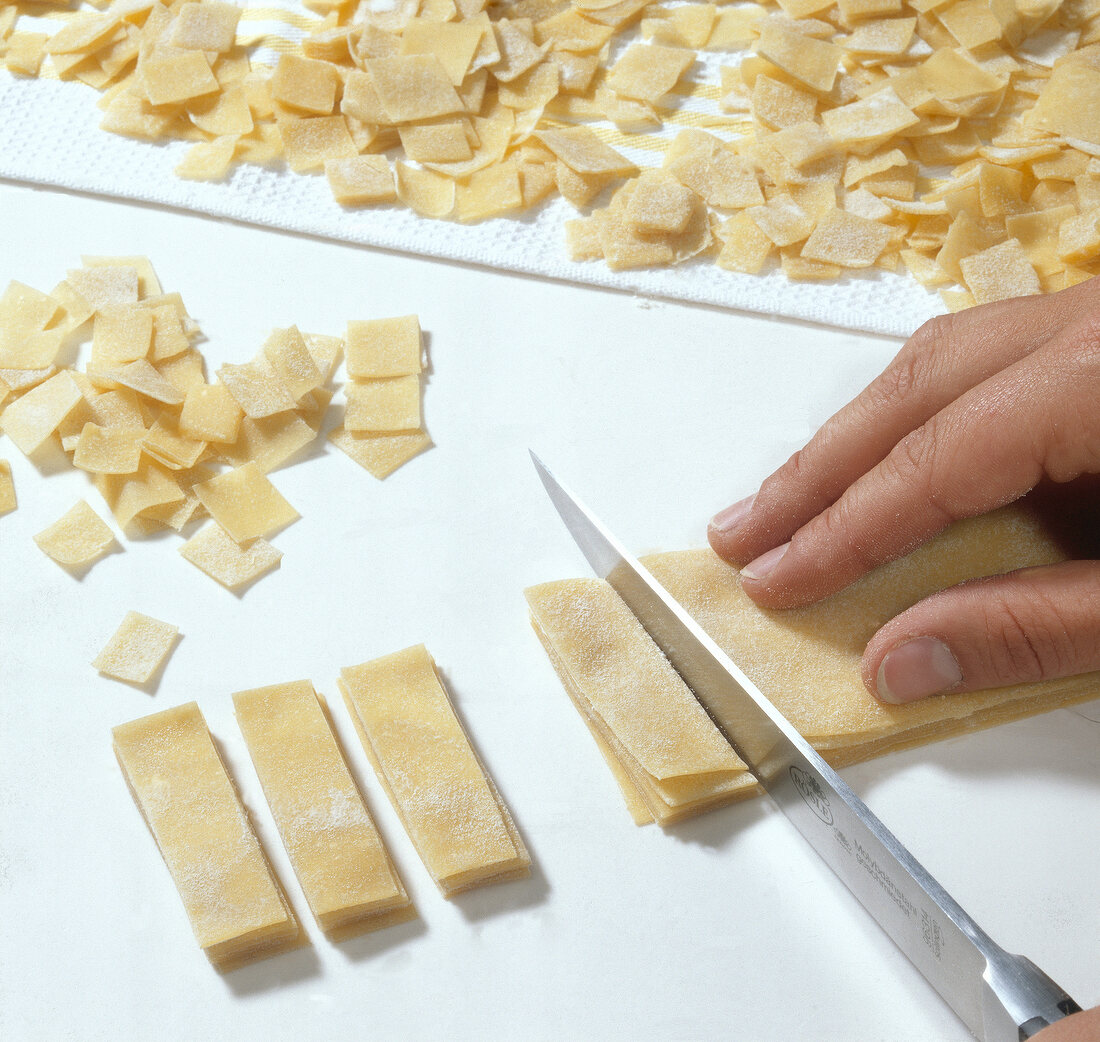 Quadrucci pasta being cut into strips and squares