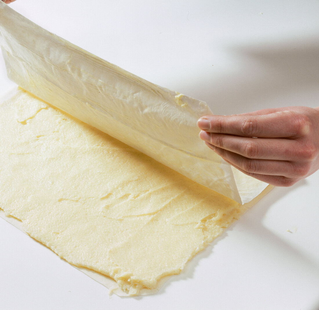 Baking paper with semolina dough being folded into half