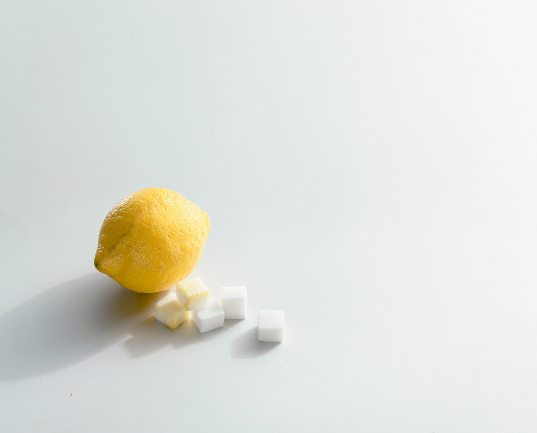 Lemon and sugar cubes on white background