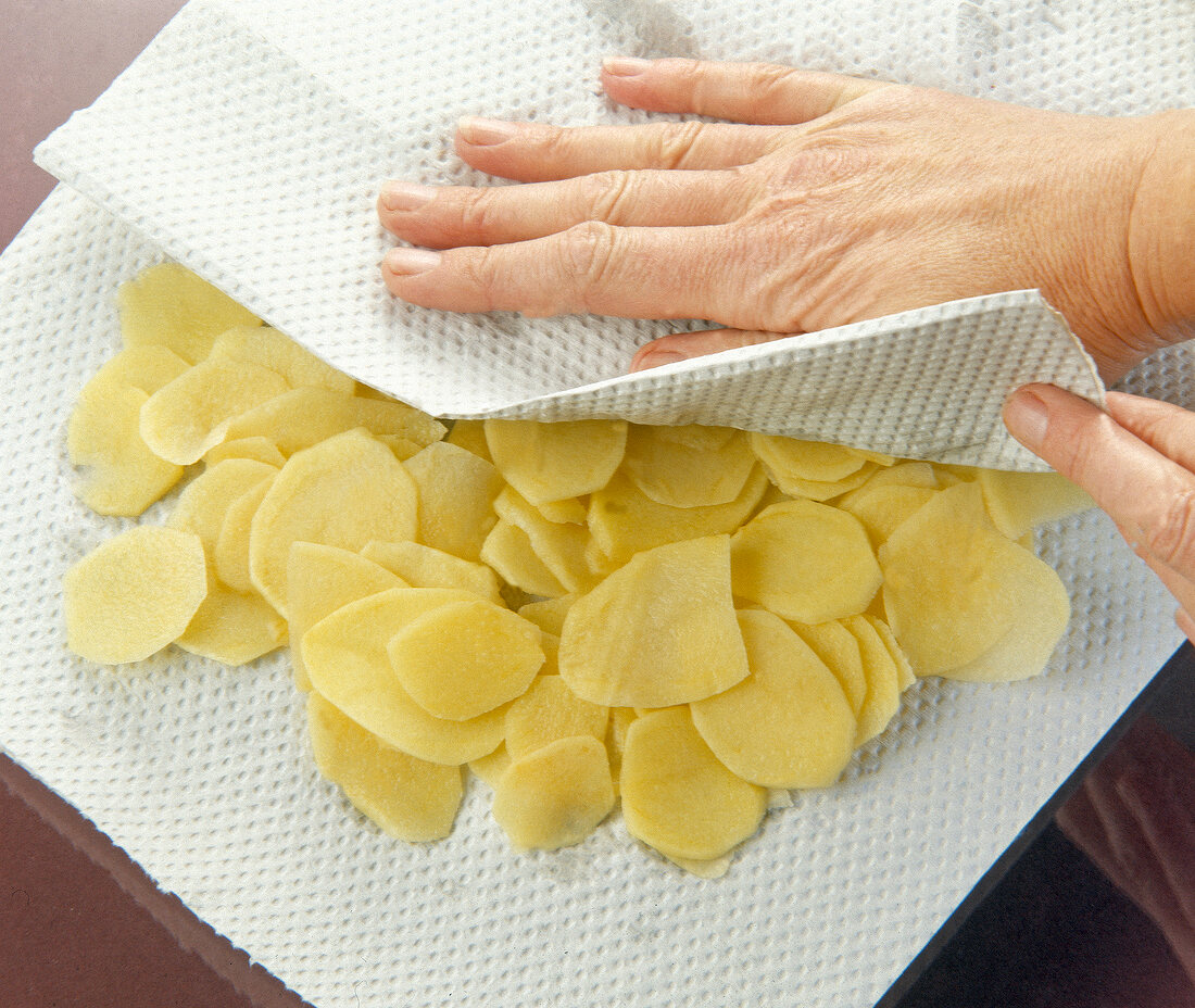 Pat drying with tissue on sliced boiled potatoes