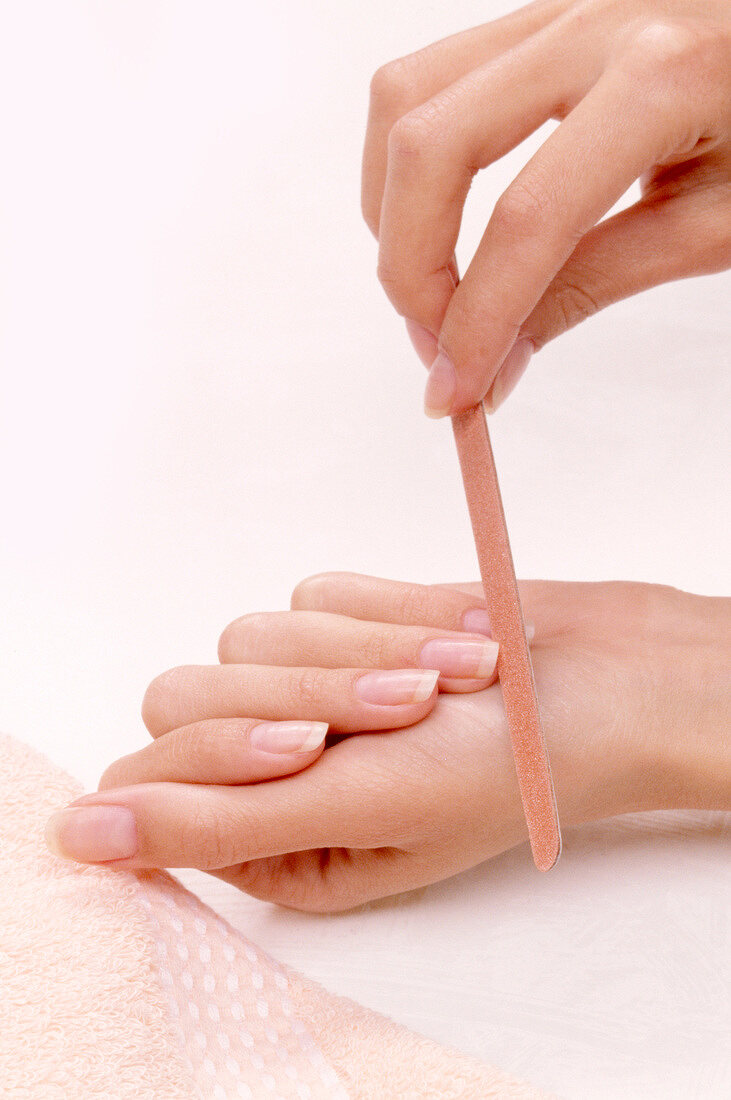 Close-up of woman filing her nails with nail file