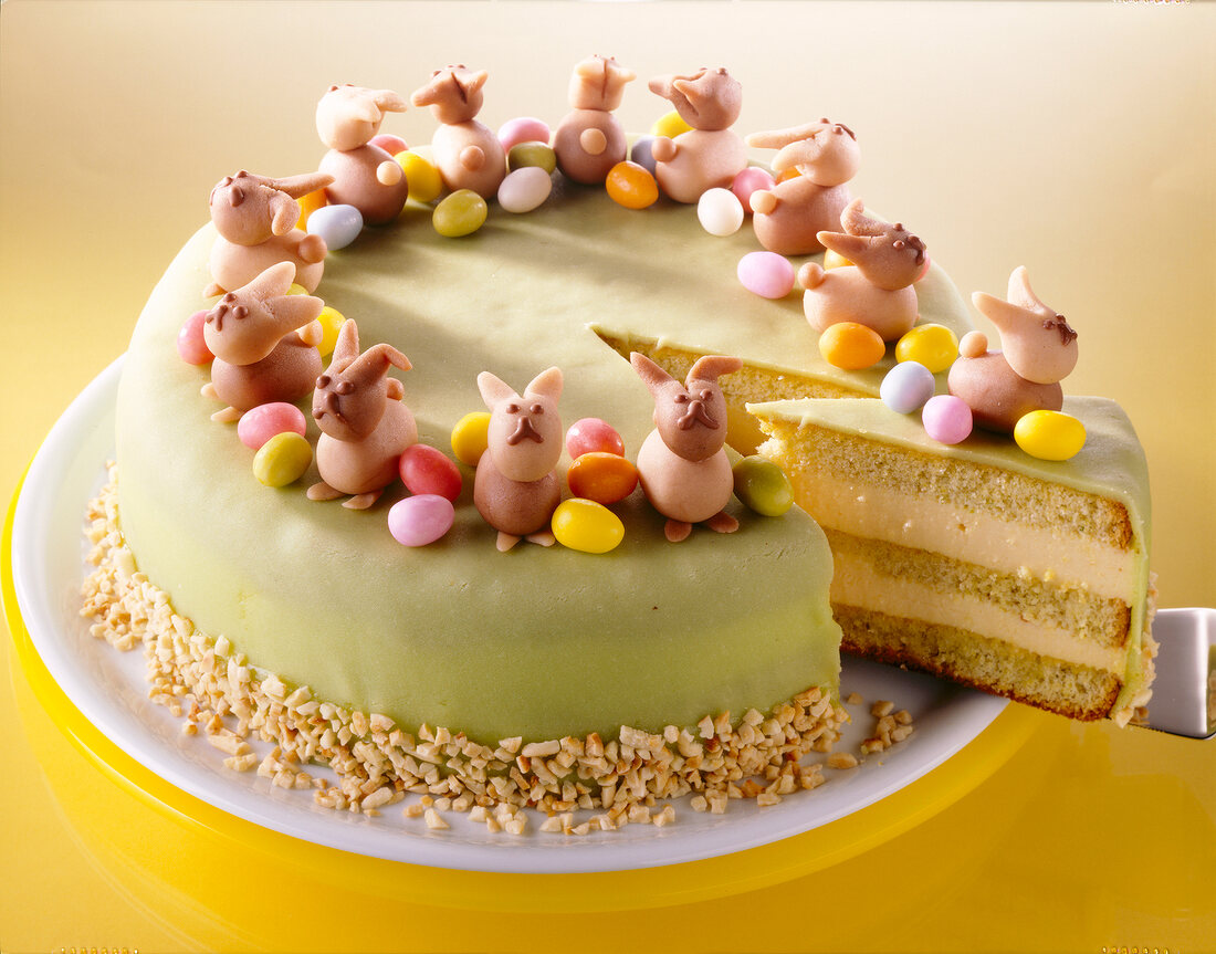 Bunte Ostertorte mit Ananas und Mar zipan, Marzipanhasen und Eiern