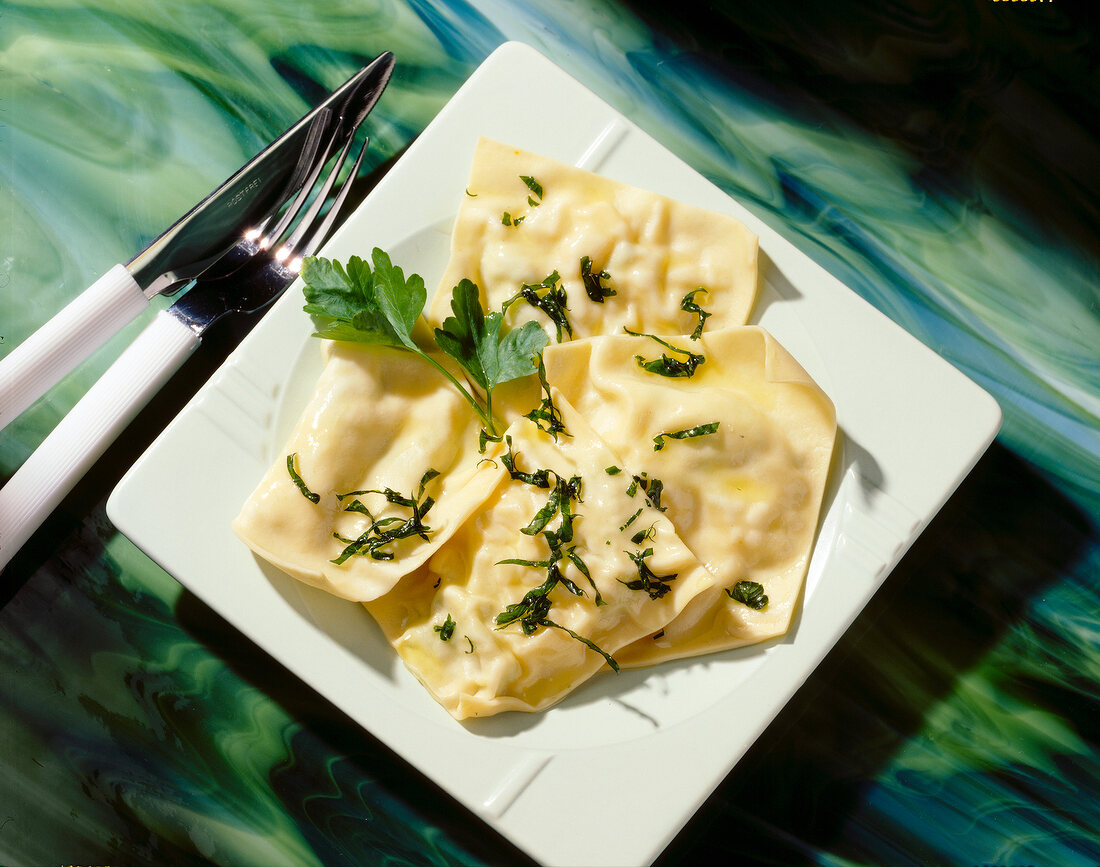 Ravioli with cheese and leek filling on square dish