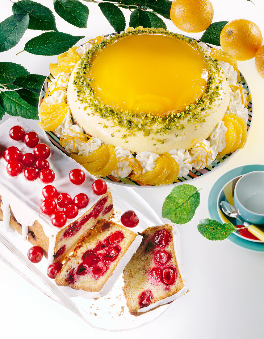 Close-up of an orange dome cake and a cherry pie