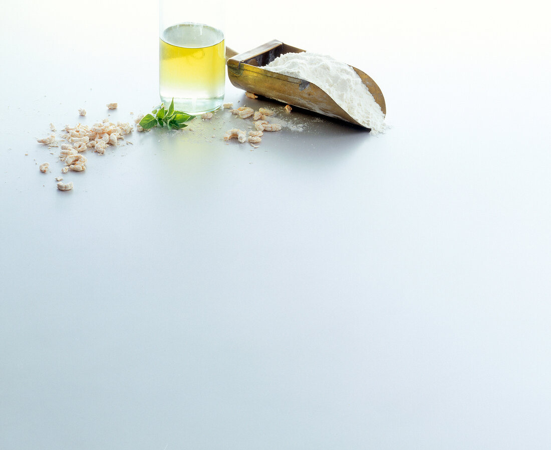 Flour scoop, oil and pieces of dried shrimp on white background