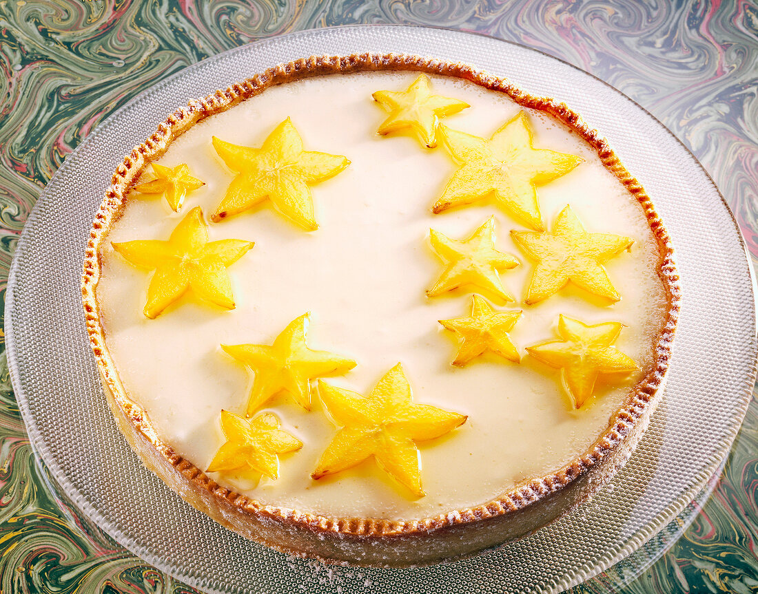 Eine Zitronen-Mürbeteigtorte mit Sternfrüchten belegt