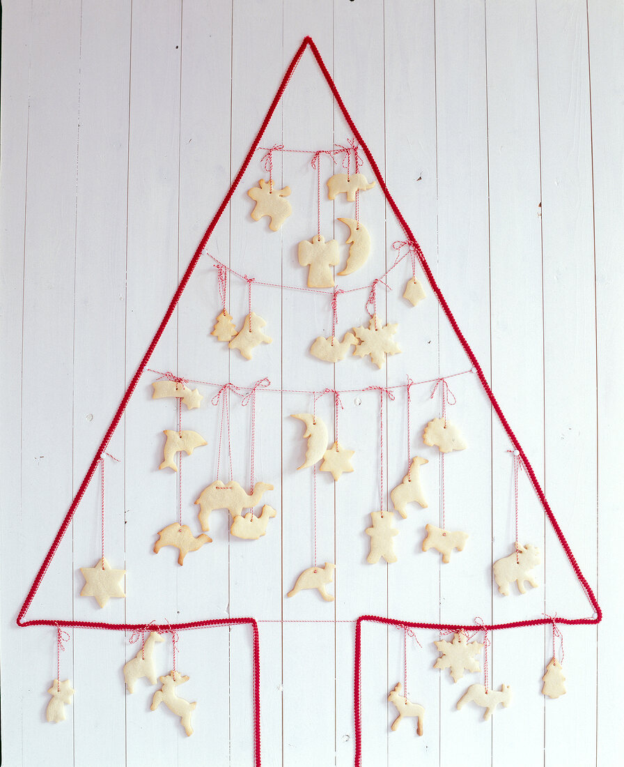 Wall Christmas tree from red cord hanging on strings across with cookies