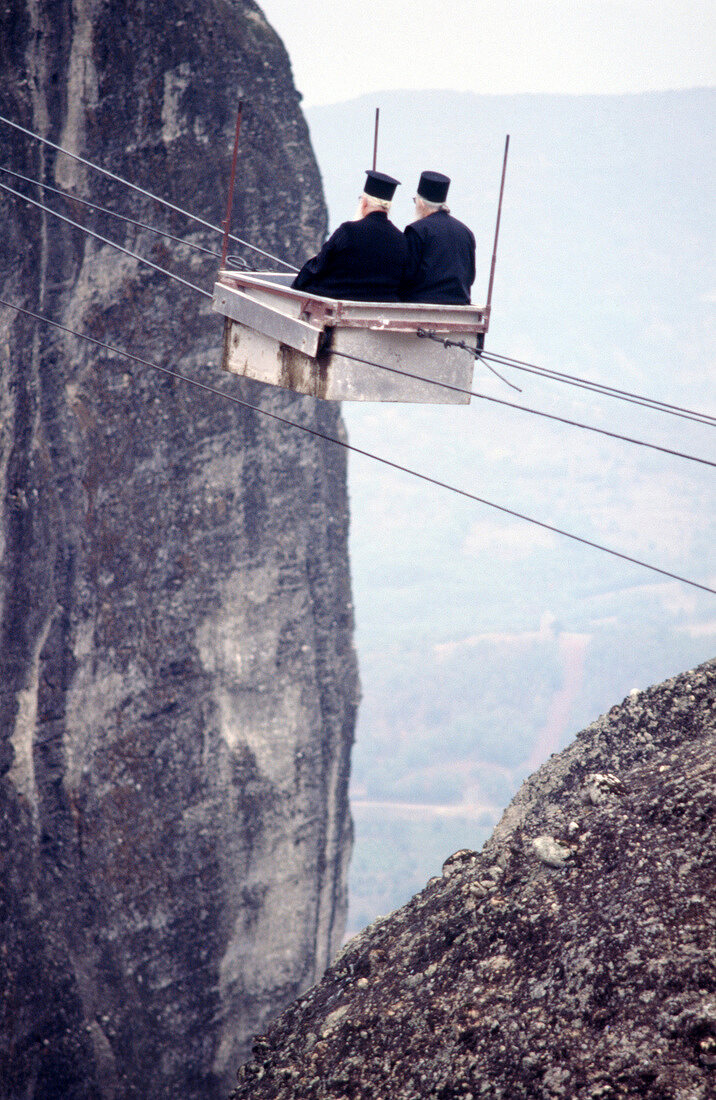Two priests travelling in cable car over Gorge and Pelion mountains, Greece