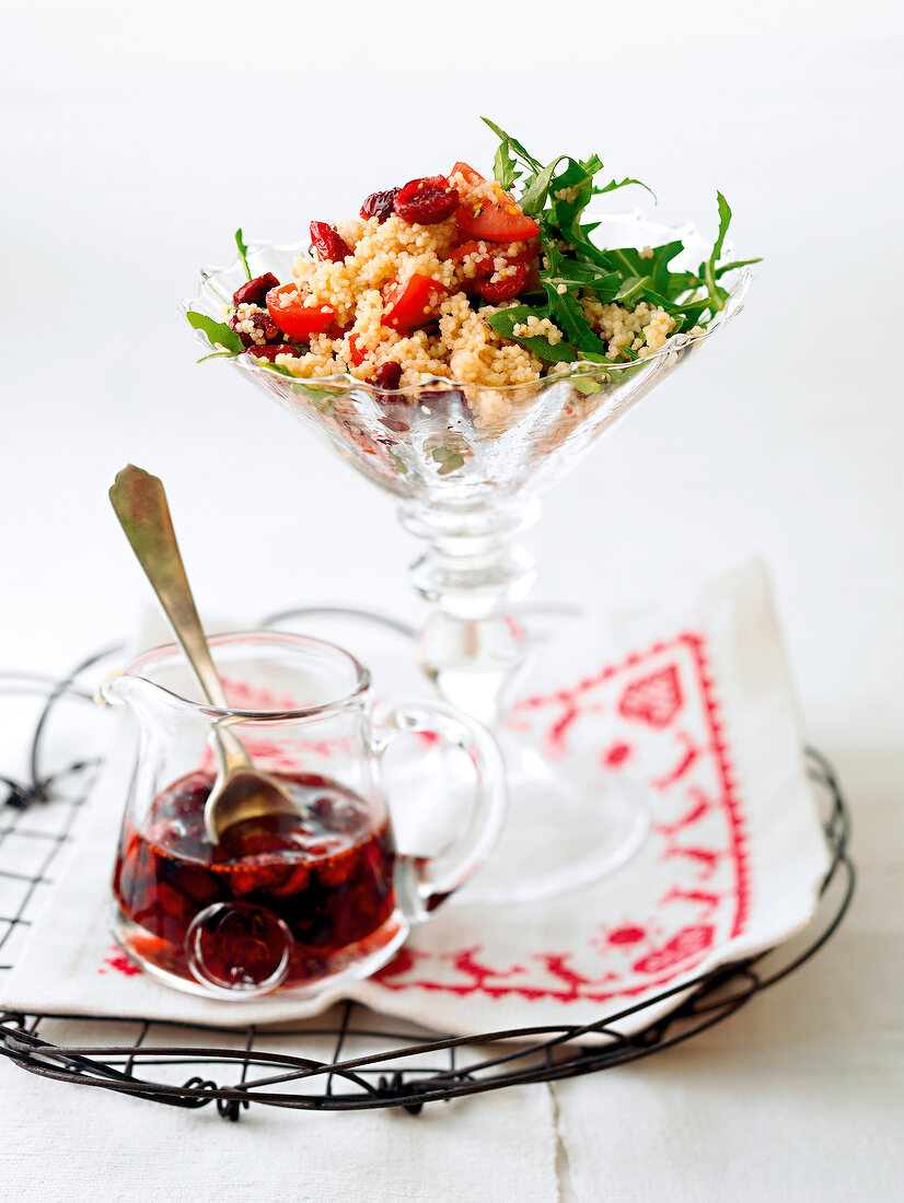 Couscous and cranberry salad with vinaigrette in jar and spoon