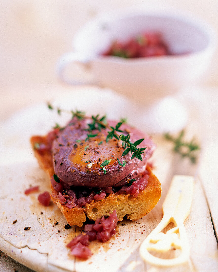 Close-up of burgundy poached egg with springs of thyme