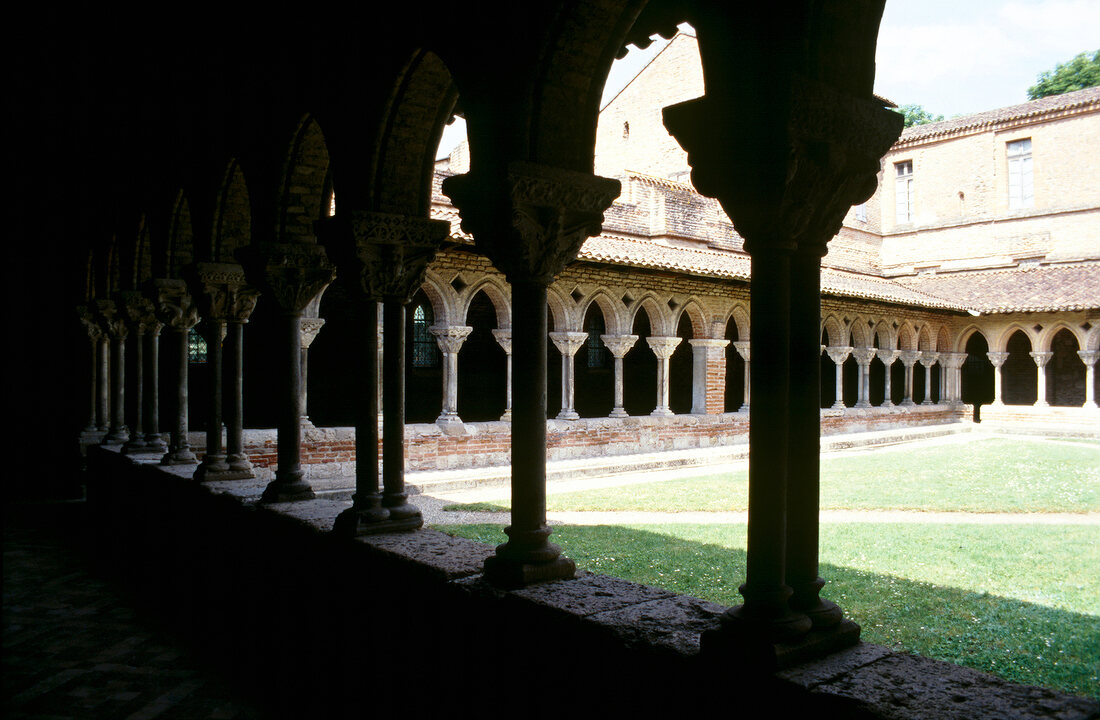 Blick durch die Säulen in den Innenhof eines Klosters in Moissac.