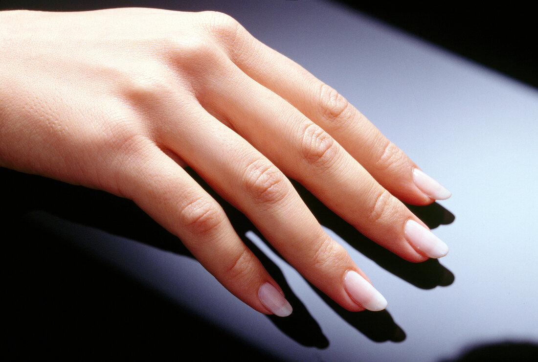 Close-up of woman's hand with well manicured fingers drying nail paint