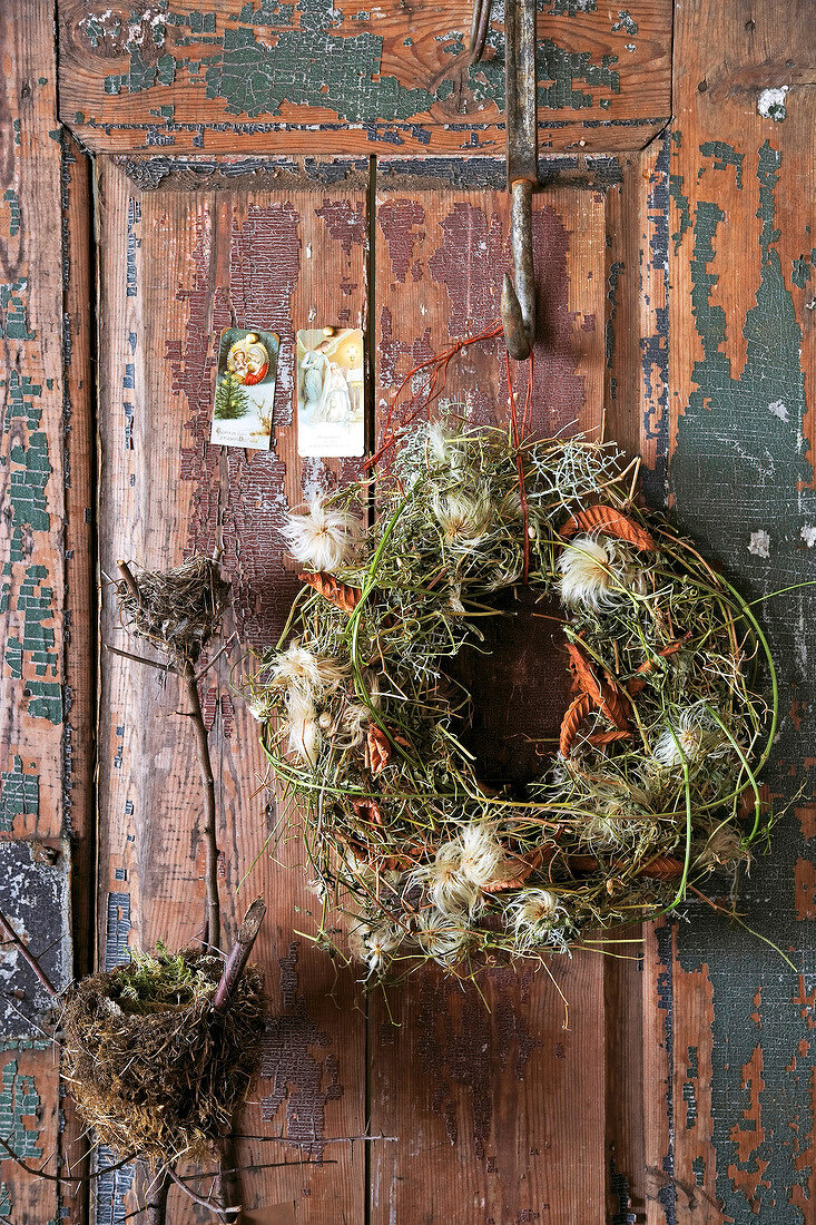 Wreath of vine clematis hanging on old wooden door