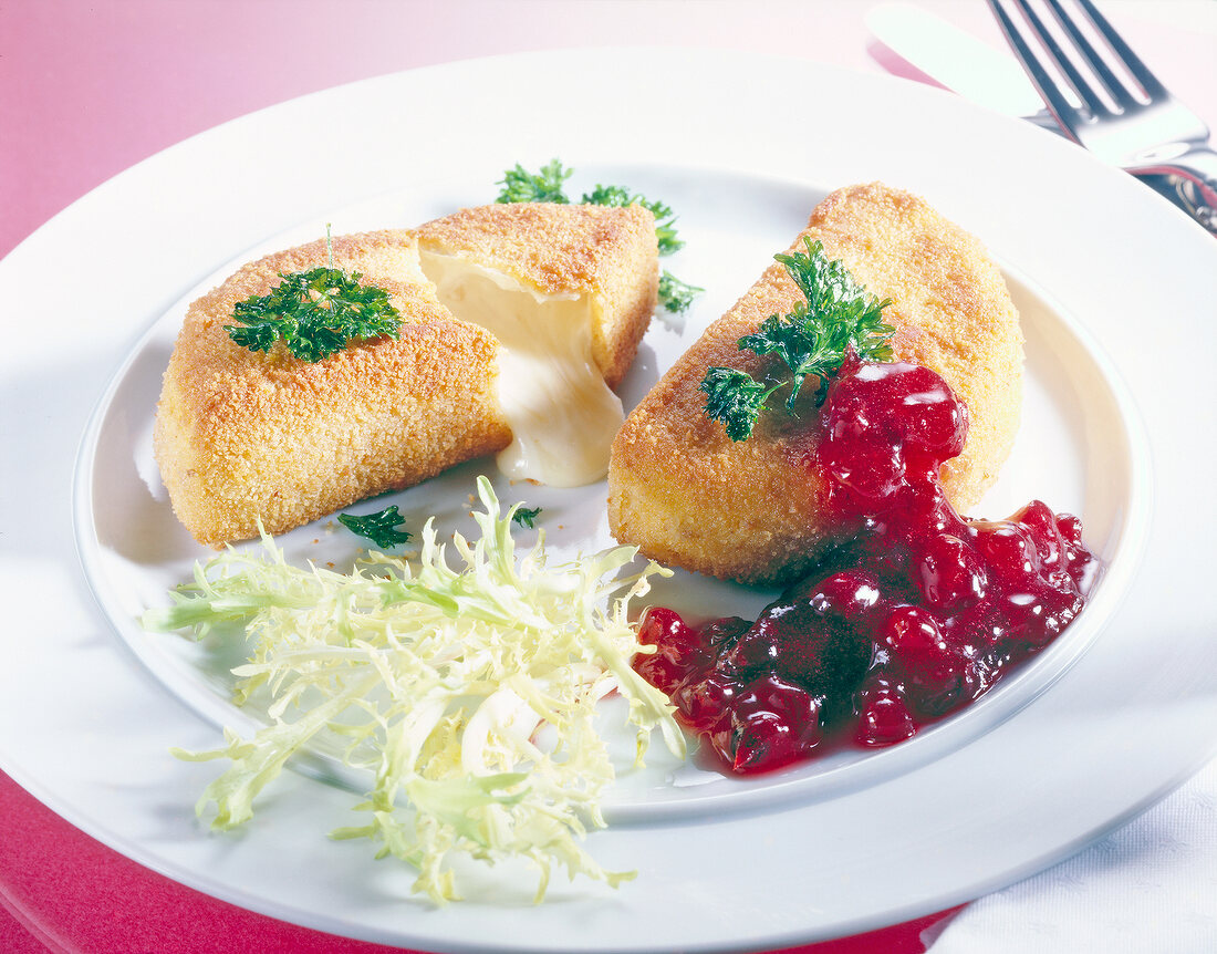 Baked Camembert with cranberries and herbs on plate