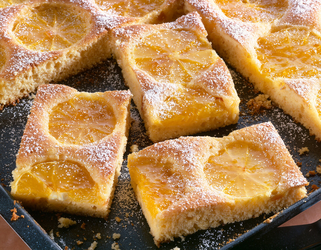 Close-up of orange cake slices on baking tray