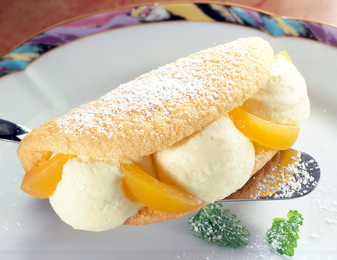 Close-up of sponge omelette with apricot cream, apricot and powdered sugar