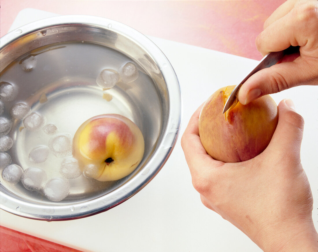 Removing skin with from peach by using kitchen knife