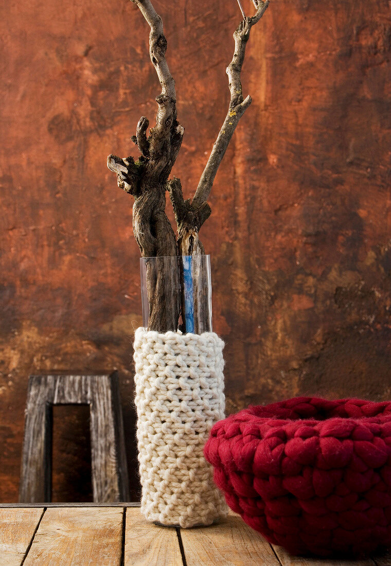 Wool knitted around vase and bowl on table