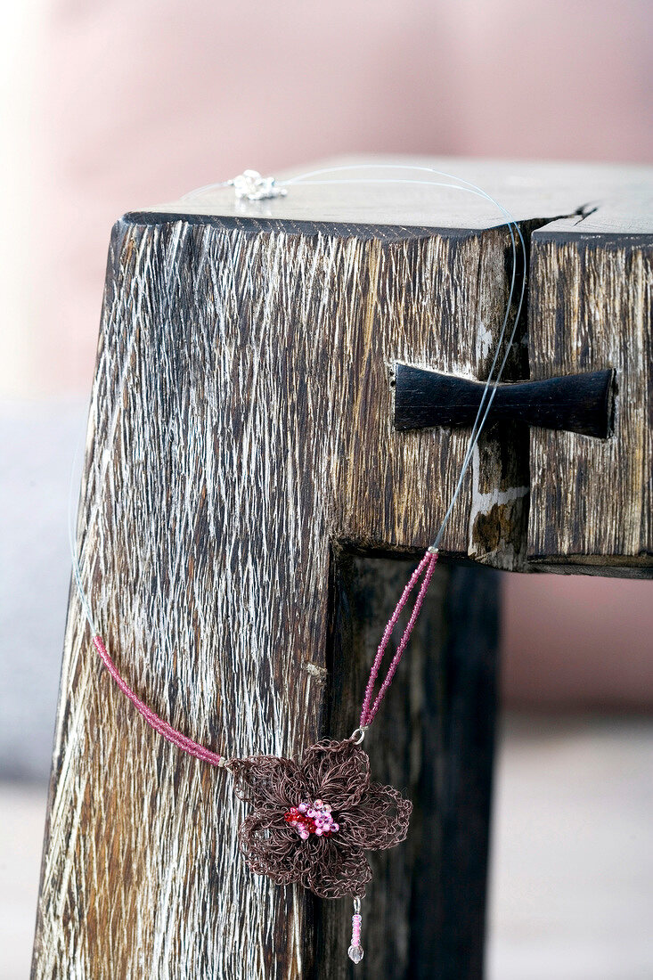 Eichenhocker mit Kette aus Häkelblume am Perlenband