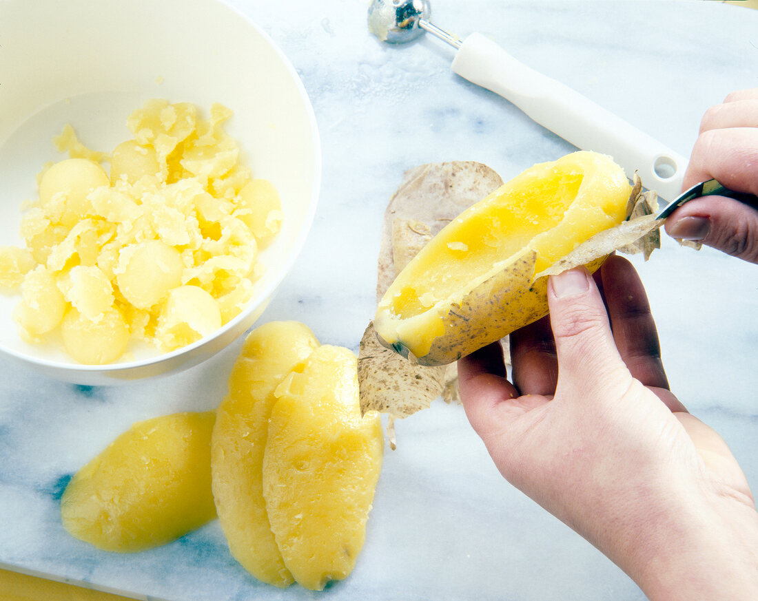 Peeling boiled potatoes with peeler