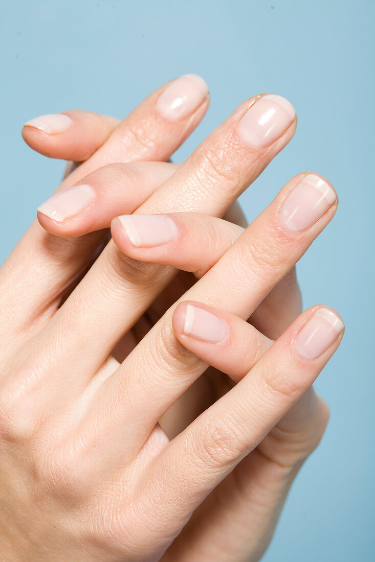 Close-up of woman's well manicured hands with intertwined fingers